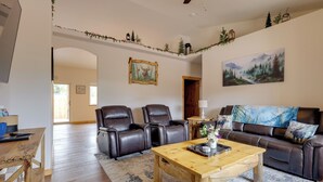 Un salon avec une table basse en bois, deux canapés en cuir, un tableau et une cheminée.