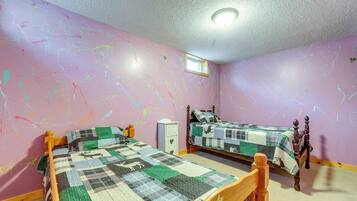 A bedroom with two beds, a window, and a ceiling light.