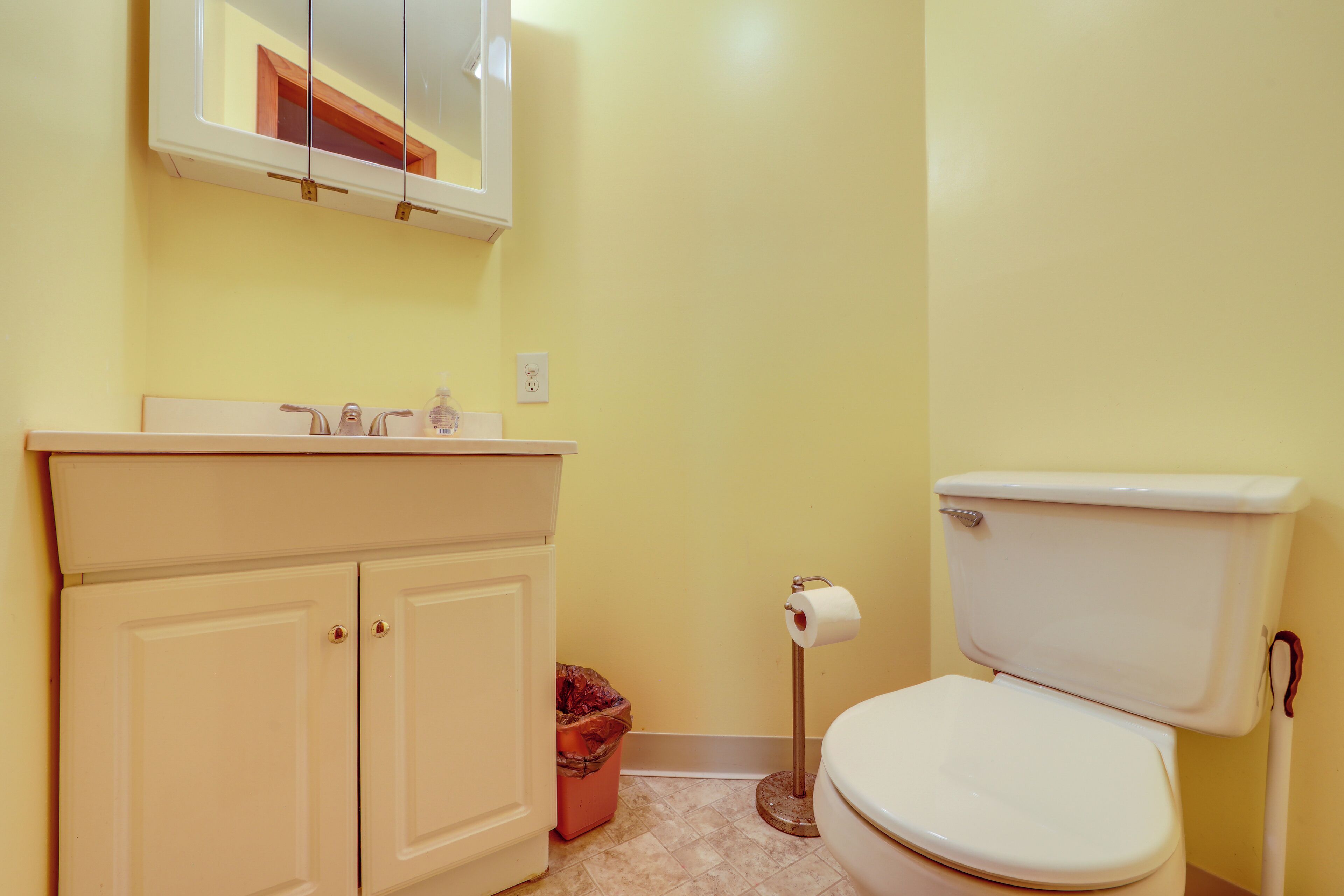 Une salle de bain avec des toilettes, un lavabo et un meuble de rangement.