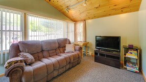A living room with a brown sofa, a television, and a bookshelf. - 12 Mi to Old Forge Pond! Group Basecamp w/ Grill (Forestport)