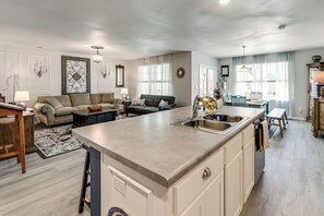 A spacious living area with a large island, a dining table, and a kitchen with a sink. - 6 Mi to Camp Lejeune! Family Home w/ Koi Pond (Jacksonville)