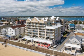 Ein mehrstöckiges Hotel in Strandlage mit Balkonen, einem Poolbereich und Meerblick.