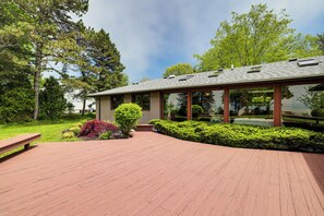A modern building with a sloped roof, large windows, and a wooden deck.