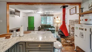 A kitchen with granite countertops, a red chimney, and a green door. - Walk to Town: Fayetteville Retreat w/ Hot Tub! (Fayetteville)