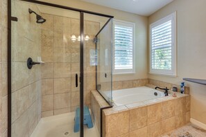 A bathroom with a glass-enclosed shower, a bathtub, and a window with blinds. - Spacious + Pet-friendly Family Home in Tracy (Tracy)