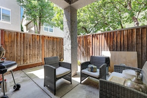A patio area with wicker furniture, a barbecue grill, and a wooden fence. - Spacious + Pet-friendly Family Home in Tracy (Tracy)