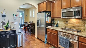 A kitchen with wooden cabinets, stainless steel appliances, and a granite countertop. - Spacious + Pet-friendly Family Home in Tracy (Tracy)
