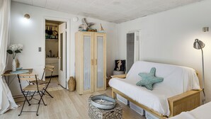 A room with a bed, a desk with chairs, a wardrobe, and a small table with decorative items. - Cozy Studio w/ Patio & Shared Pool in La Jolla! (La Jolla)
