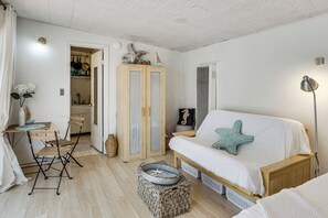 A room with a bed, a desk with chairs, a wardrobe, and a small table with decorative items. - Cozy Studio w/ Patio & Shared Pool in La Jolla! (La Jolla)