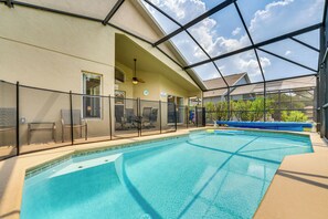 Ein Innenpool mit Glasdach, einer überdachten Terrassenfläche und Blick ins Freie.