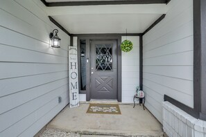 A house entrance with a gray door, a welcome mat, a lantern, and a sign that says 'WELCOME HOME'. - 3 Mi to Seaworld! Cozy Family Home w/ Patio (San Antonio)