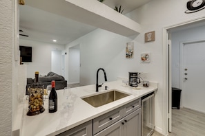 A modern kitchen with a white countertop, a sink, and a coffee maker. - 3 Mi to Seaworld! Cozy Family Home w/ Patio (San Antonio)
