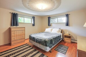 A bedroom with a bed, a nightstand, a dresser, two windows with curtains, and a ceiling light fixture. - Extended-stay Home/office, 8 Mi to Dtwn Denver (Lakewood)