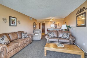 A living room with two brown leather sofas, a wooden coffee table, and a kitchen in the background. - Poolside Fun, Lake Havasu Views! Desert Getaway (Lake Havasu City)