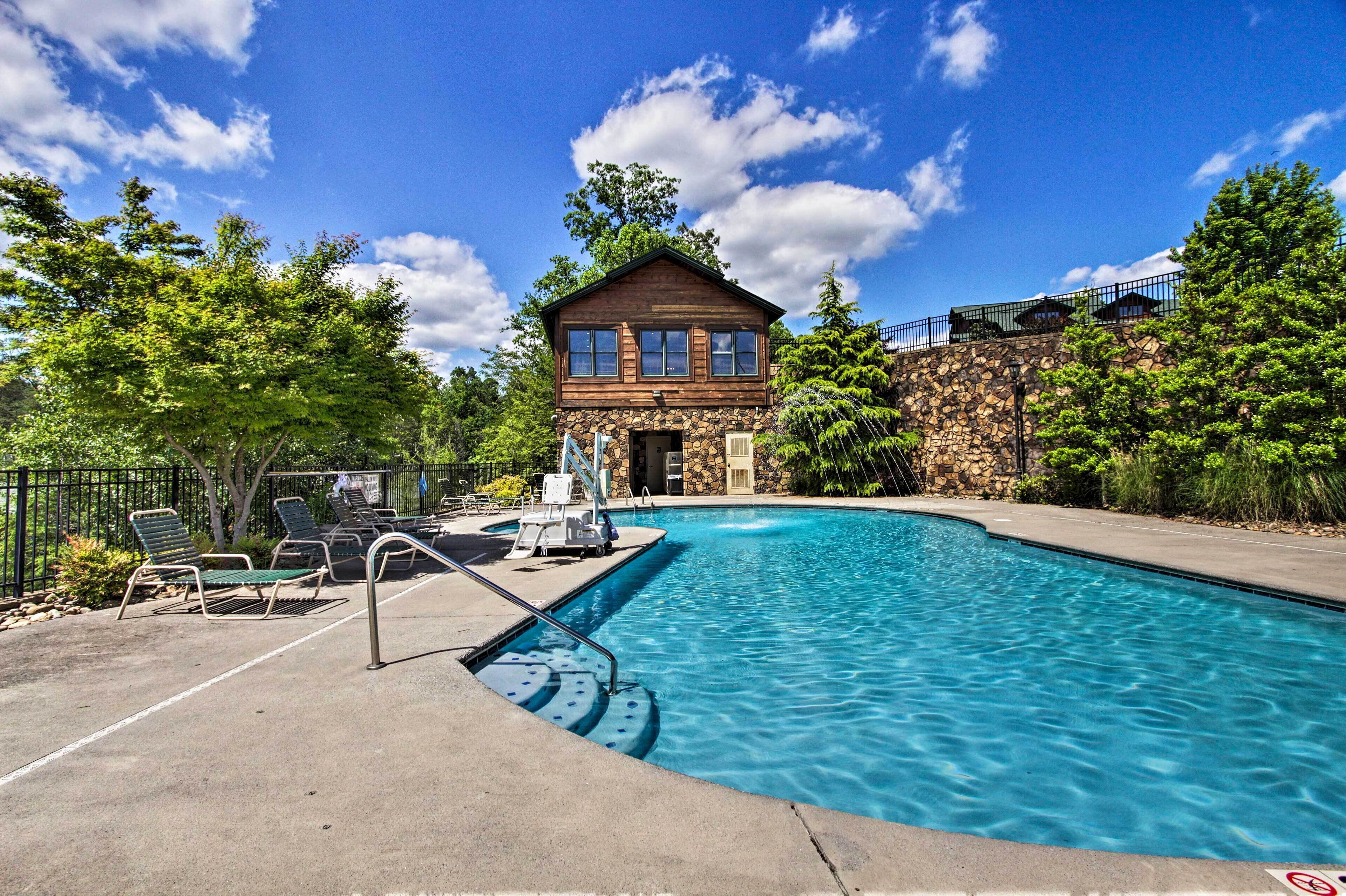 A swimming pool with lounge chairs and a stone building in the background.
