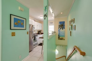 A kitchen with white cabinets, a refrigerator, and a microwave. - Bikes Provided! Central Condo w/ Pool in Key West (Key West)