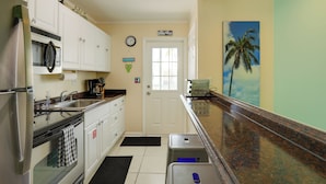 A compact kitchen with white cabinets, a stainless steel refrigerator, a microwave, and a coffee maker. - Bikes Provided! Central Condo w/ Pool in Key West (Key West)