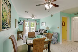 A dining area with wicker chairs, a glass-top table, and a ceiling fan. - Bikes Provided! Central Condo w/ Pool in Key West (Key West)