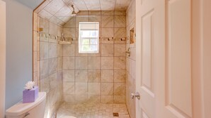 Ein Badezimmer mit Dusche, Fenster und Toilette.