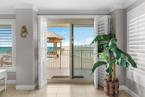 Ein Zimmer mit einer Schiebetür zum Balkon, einem Blumentopf und einer Wanddekoration.