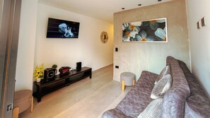 A living room with a flat-screen TV, a sofa, a coffee table, and a decorative wall piece. - Baruch IV Itagüí: 2 bedrooms + private hot tub + balcony + A/C (Itagüí)