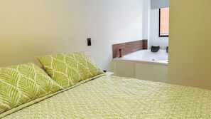 A room with a bed, a window, and a small bathroom area. - Baruch IV Itagüí: 2 bedrooms + private hot tub + balcony + A/C (Itagüí)