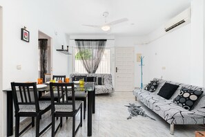 A dining area with a table and chairs, a sofa, and a coat rack. - Apartment Ground floor Doña Ines Torrevieja (Torrevieja)