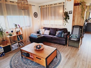 Ein gemütliches Wohnzimmer mit einer Couch, einem Couchtisch und einem Bücherregal.