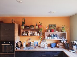 Eine Küche mit eingebautem Backofen, einem Holzkasten und verschiedenen Küchenutensilien auf der Arbeitsfläche.