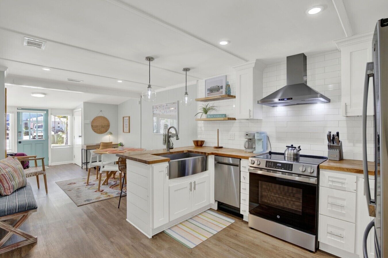 A modern kitchen with white cabinetry, a stainless steel stove, and a built-in oven.