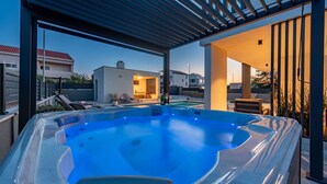 Un jacuzzi con vistas despejadas del entorno, incluyendo un edificio moderno y una piscina.