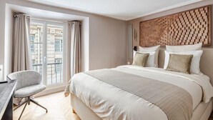 A hotel room with a bed, a desk, and a window with curtains. - Palais Royal - Prestige between the Louvre and the Opera (Paris)