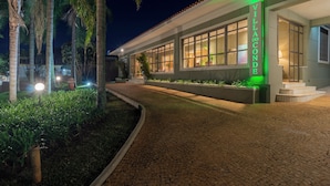 A villa with a paved walkway, large windows, and a sign reading 'Villa do Conde.' - Pousada Villa do Conde (Brotas)