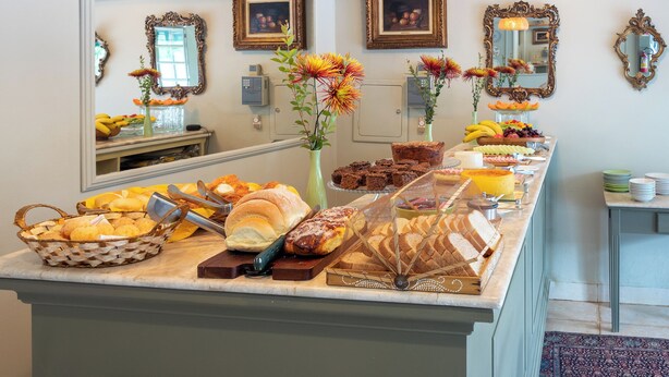 A buffet with various breads, pastries, and fruits. - Pousada Villa do Conde (Brotas)