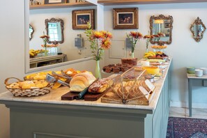 A buffet with various breads, pastries, and fruits. - Pousada Villa do Conde (Brotas)