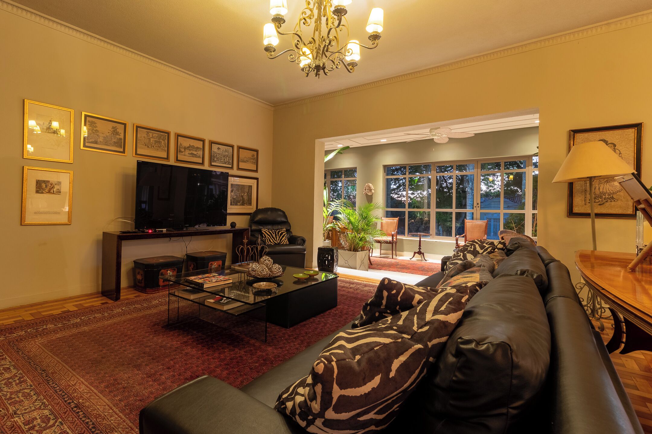A living room with a sofa, a coffee table, a TV, and framed pictures on the wall.