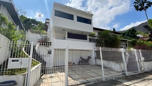 Ein modernes, zweistöckiges Gebäude mit weißer Fassade, einem befahrten Eingang und einer Satellitenschüssel.