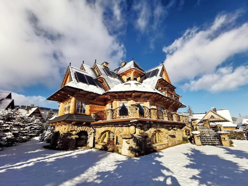Un edificio cubierto de nieve con un estilo arquitectónico distintivo, con varios niveles y un balcón destacado.