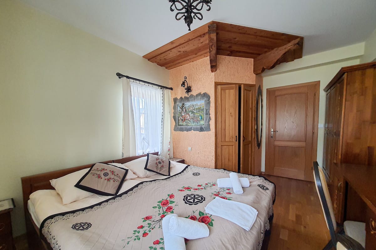 Un dormitorio con cama, armario de madera y un cuadro en la pared.