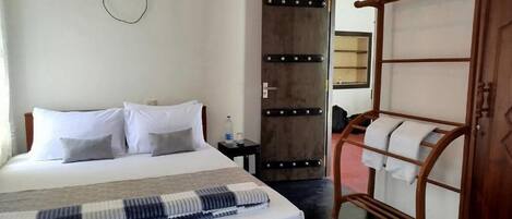 A bedroom with a bed, bedside table, and a wardrobe.