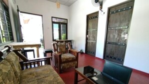 A room with a sofa, a table, a laptop, and two doors. - Step Inn Ahangama  (Ahangama)