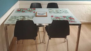 Un comedor con una mesa, sillas y un cuadro en la pared.
