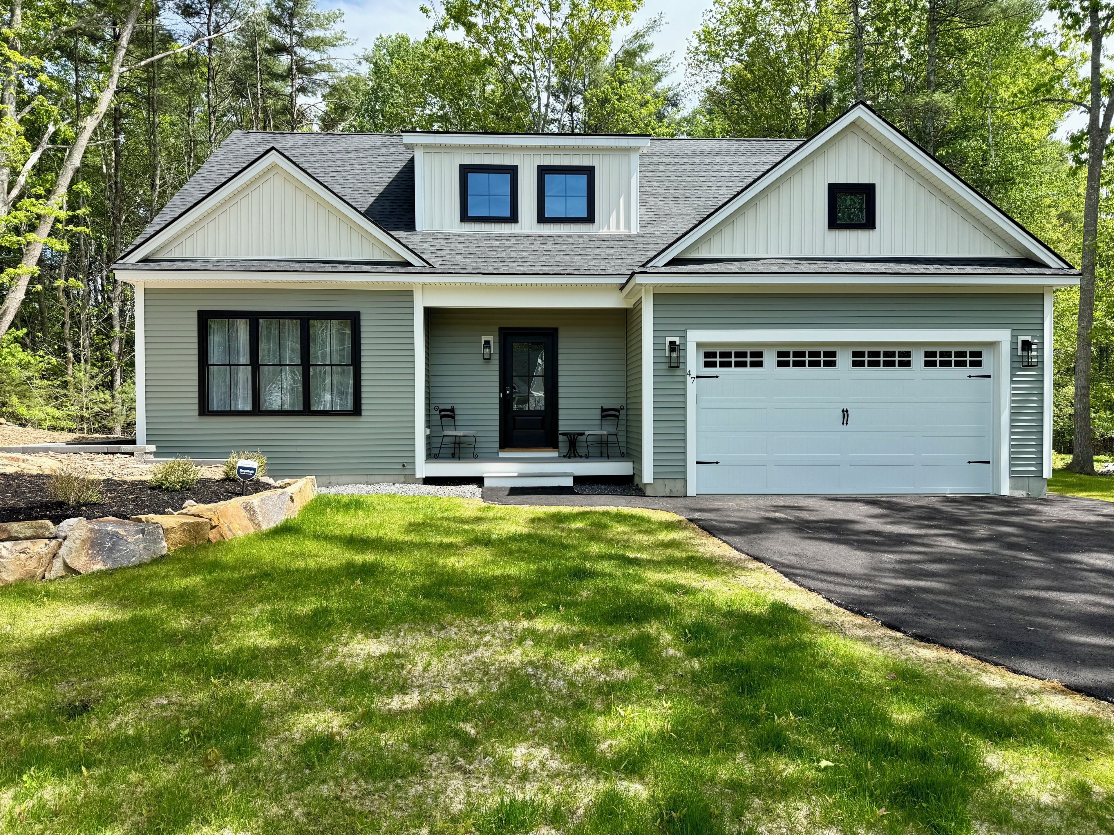 A two-story house with a front porch, a garage, and a well-maintained lawn.