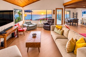 A spacious living area with a large window overlooking the ocean, a comfortable seating arrangement, and a dining area. - Oceanfront Retreat, Amazing Ocean Views W/Jacuzzi! (Ventura)