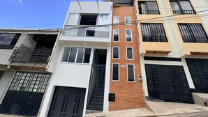 A multi-story residential building with a mix of brick and plaster exteriors, multiple balconies, and a variety of window styles. - GUADUAS, CLOSE TO THE HISTORICAL CENTER, PET FRIENDLY, APARTMENT2H+2B,WIFI -PARKING (Guaduas)