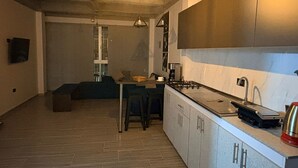 A modern kitchen with a built-in island, a gas stove, and a coffee machine. - GUADUAS, CLOSE TO THE HISTORICAL CENTER, PET FRIENDLY, APARTMENT2H+2B,WIFI -PARKING (Guaduas)