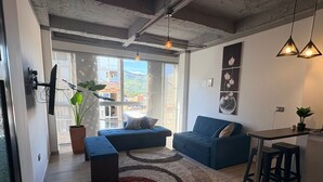 A modern living room with a sofa, a small table, and a potted plant. - GUADUAS, CLOSE TO THE HISTORICAL CENTER, PET FRIENDLY, APARTMENT2H+2B,WIFI -PARKING (Guaduas)