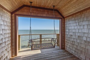 A wooden deck with a swing chair overlooking a body of water. - Water Wonderland - Panoramic Water Views, Dockage Available, Core Sound (Sea Level)