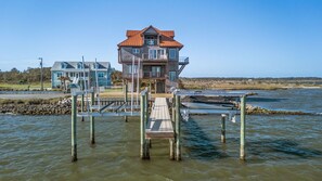 A waterfront property with a multi-level house, dock, and boats. - Water Wonderland - Panoramic Water Views, Dockage Available, Core Sound (Sea Level)