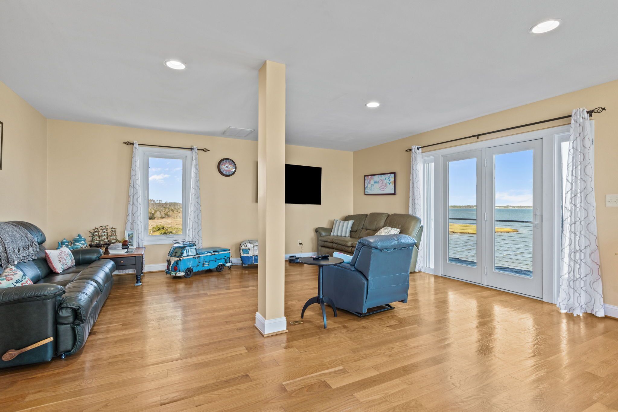 A spacious living area with a sofa, armchair, and a small table.